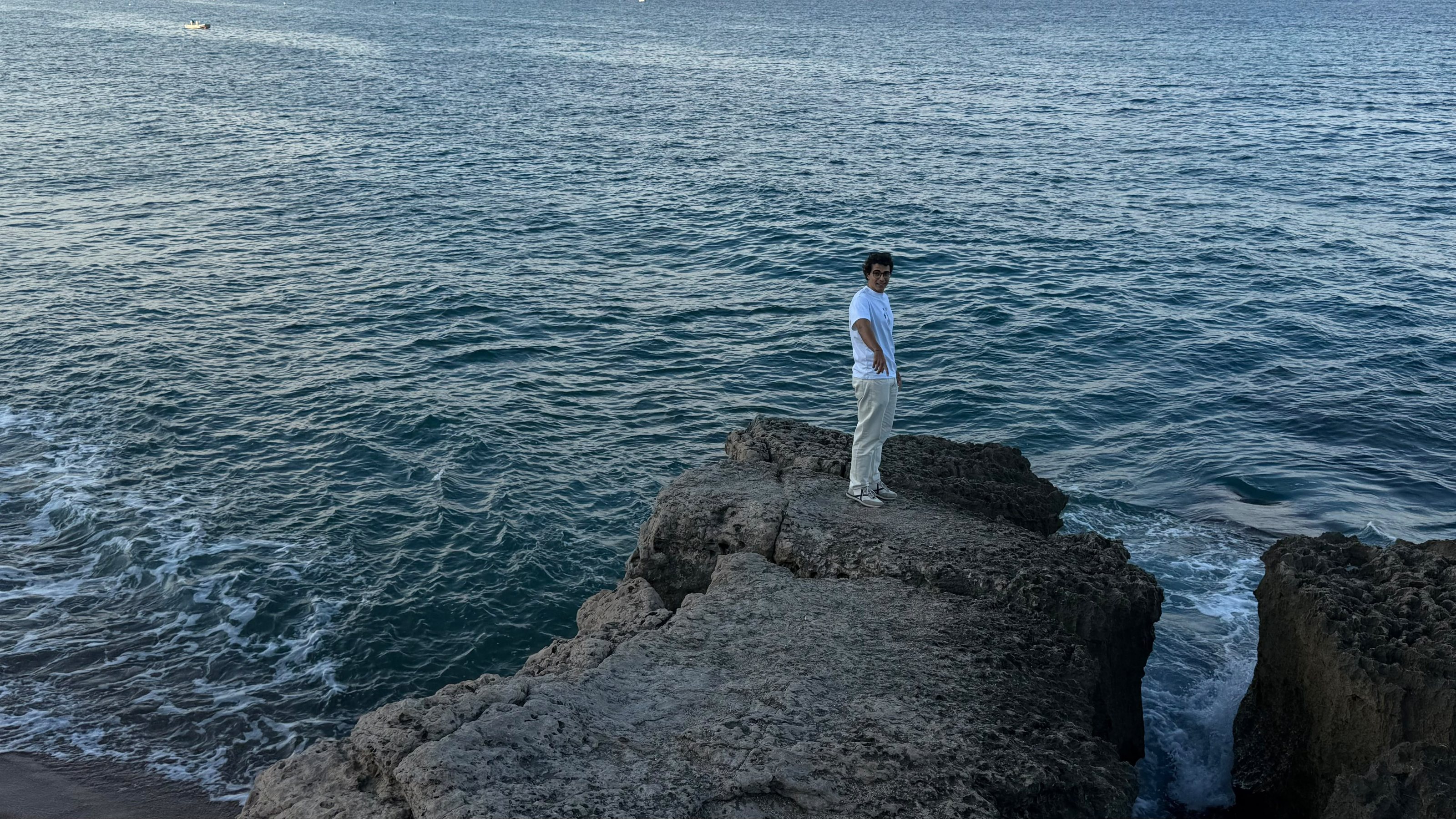 Pol Àlvarez dret sobre una roca davant del mar